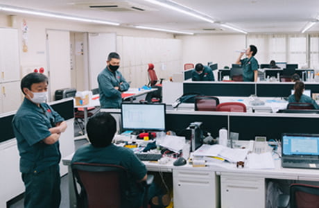 事務スペースで複数の社員が話をしている写真