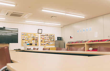 会議室の写真。複数人が座れる大き目の机とテレビが設置されている。