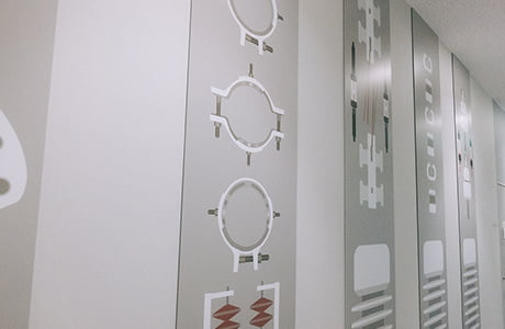 工場内の壁に製品のイラストが複数描かれている写真